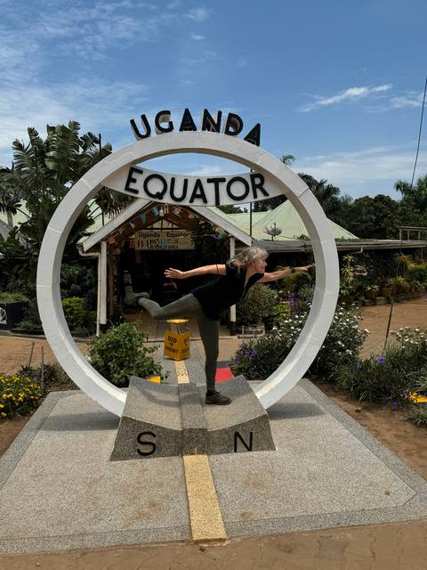       Someone posing with a Uganda Equator sign.
  