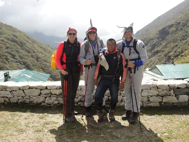 Four people posing outdoors in mountain attire.
