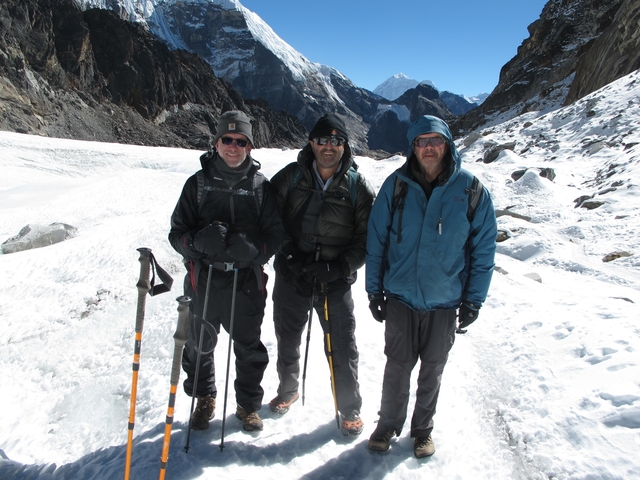 Three hikers posing on a snowy mountain path.