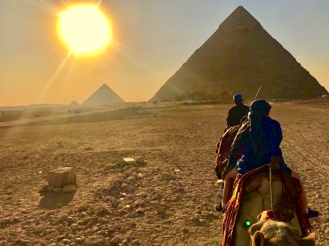       Camel riders near the Pyramids at sunset.
  