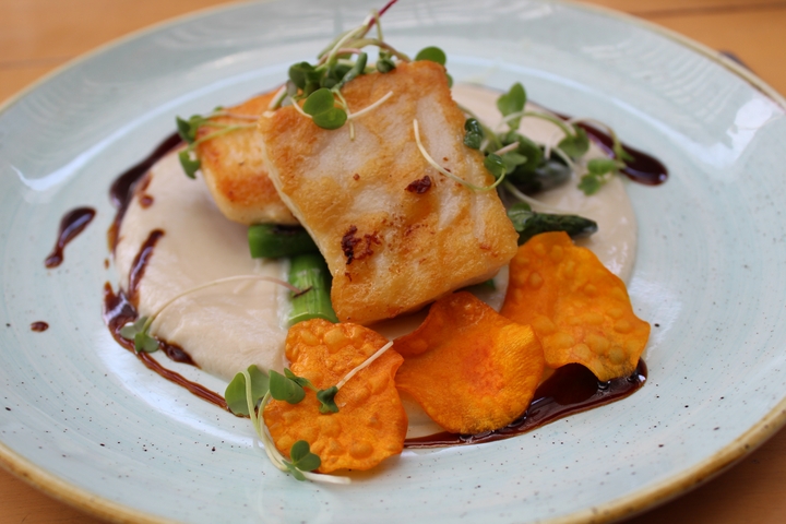       Gourmet dish with fried fish and vegetable garnish on a plate.
  