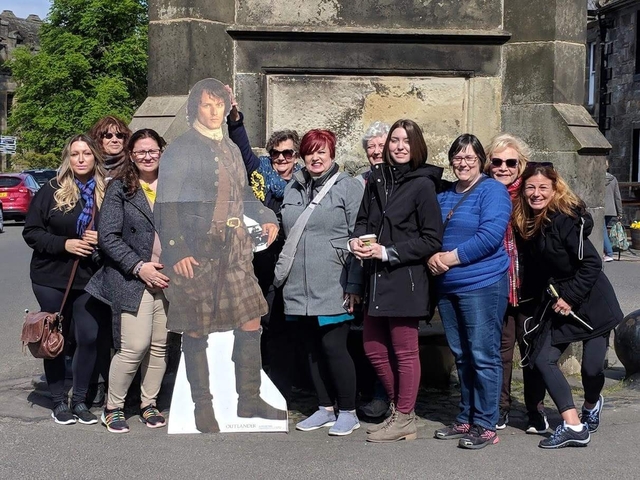 Group photo with cutout of a person in traditional Scottish attire.