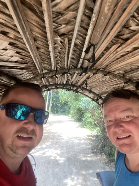 Close-up of two people under a thatched roof