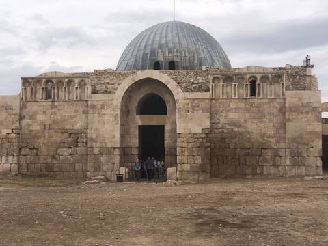       Ancient stone building with dome and archway.
  