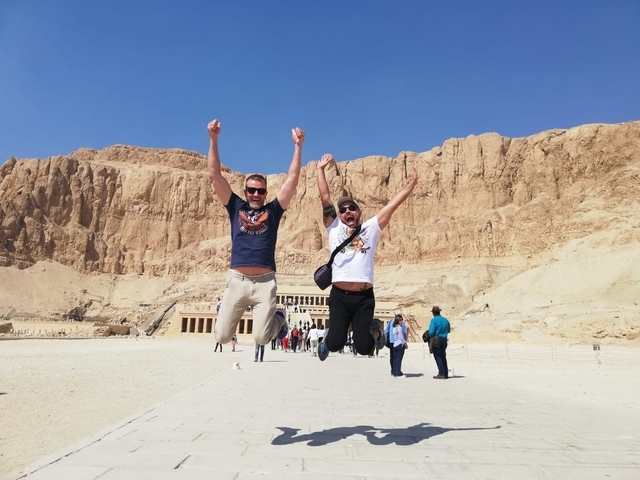 Two men jumping in front of the Hatshepsut Temple.