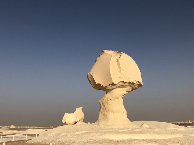 Oddly shaped white rock formations against a clear sky.