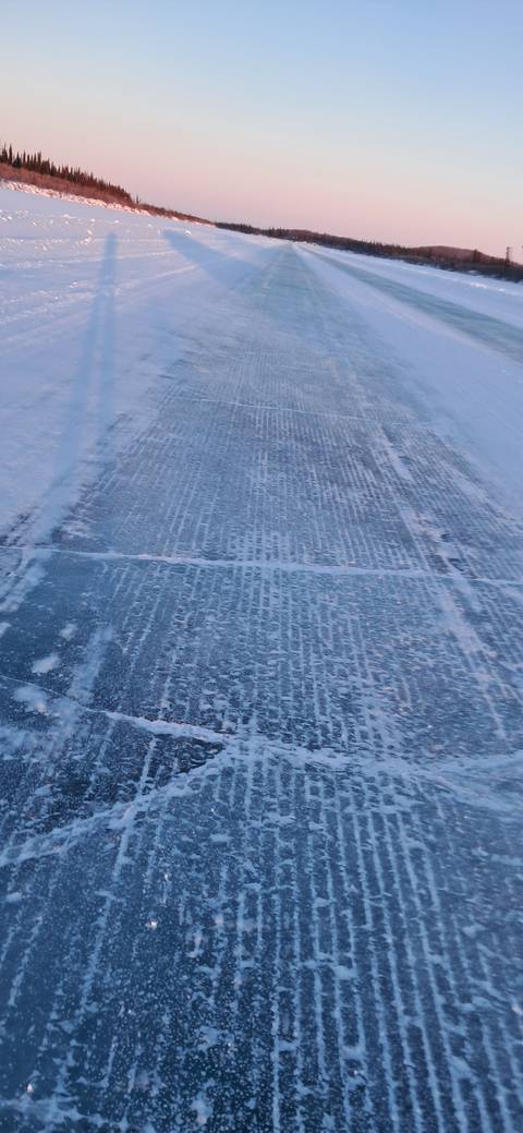       Frozen river with visible tracks and ice formations.
  