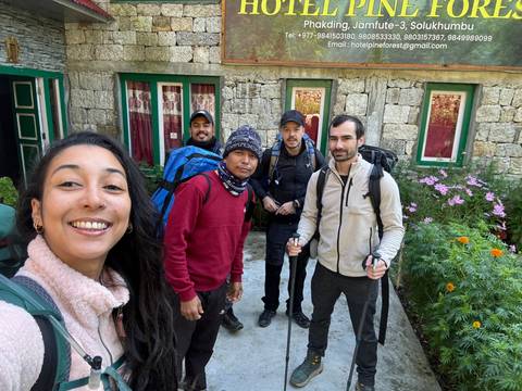       Group posing in front of a building with plants around.
  