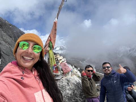       Group smiling with mountain and sky backdrop.
  