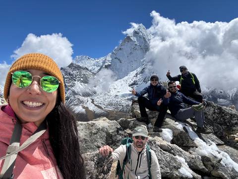      Group of people posing with mountains in the background.
  