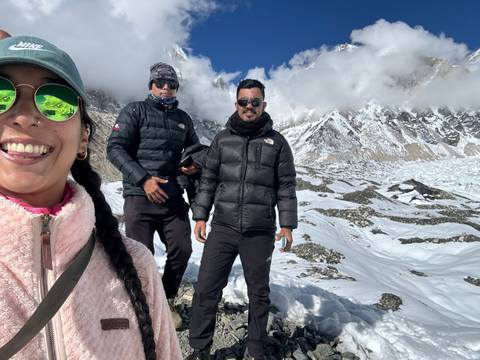       Two people smiling on a snowy mountaintop.
  