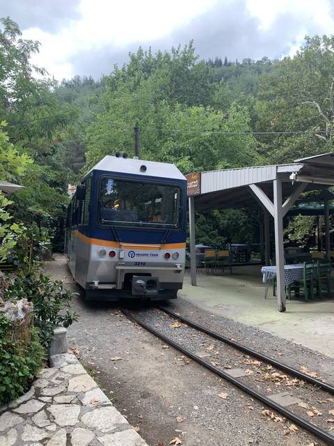       Small train at a rustic outdoor station.
  