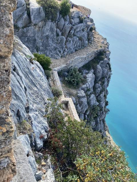 Stone wall with vegetation on a rocky outcrop.
