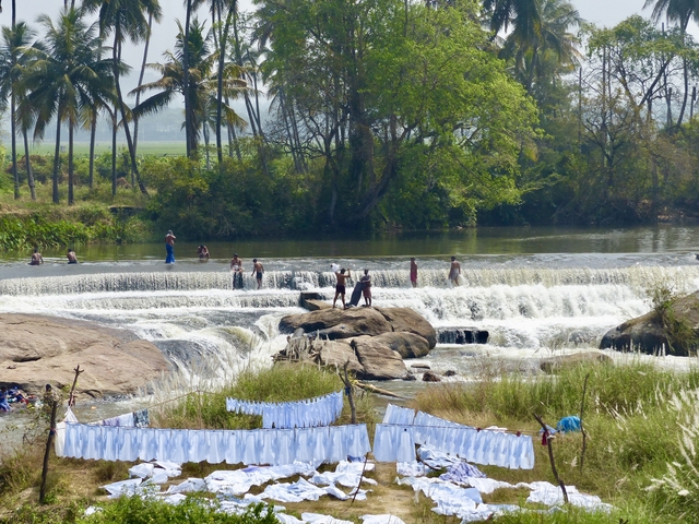       People enjoying a waterfall in a natural setting.
  