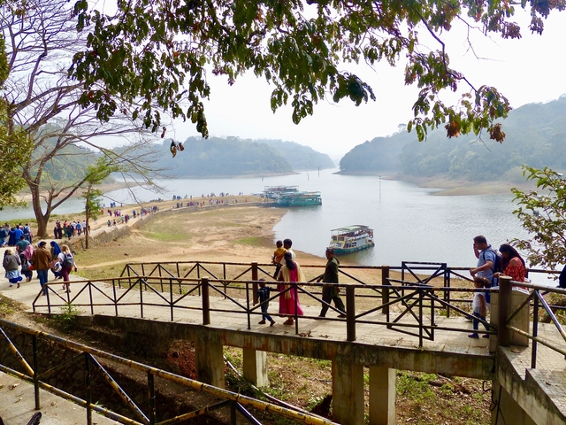       A bridge over a winding river with groups of people.
  