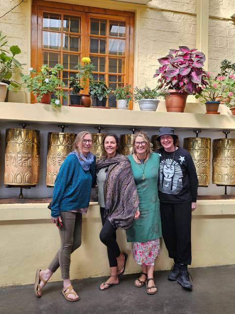 Four people with a decoratively painted wall.