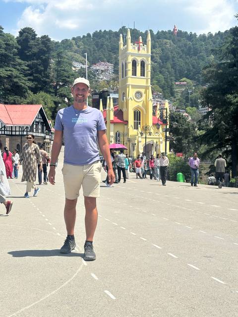 Man posing in front of a city landmark.