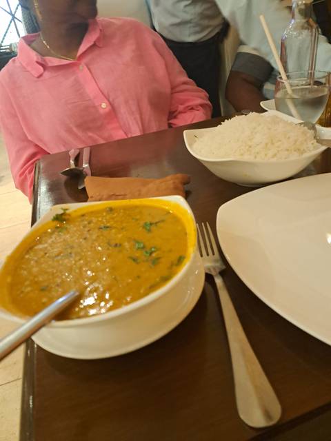 Dining table with Indian dishes being served.