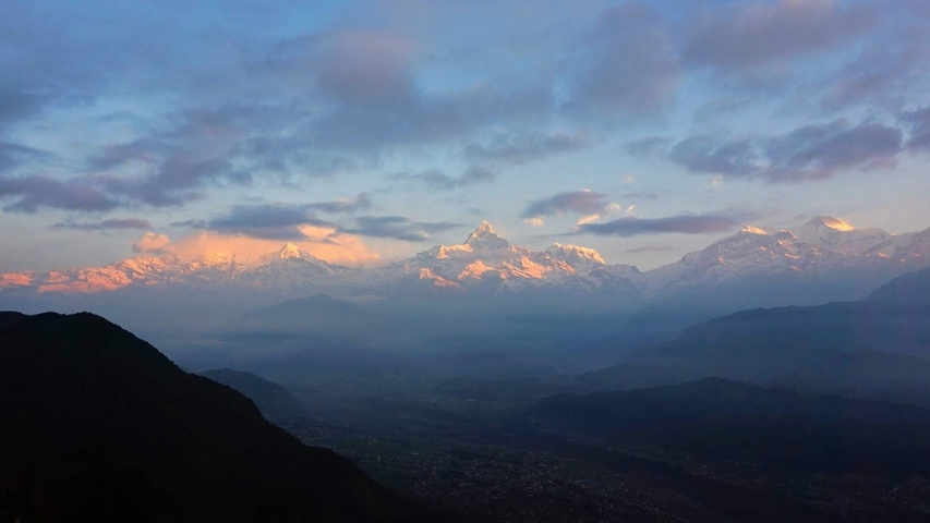 Snow-capped mountains under a clear blue sky with valleys visible.