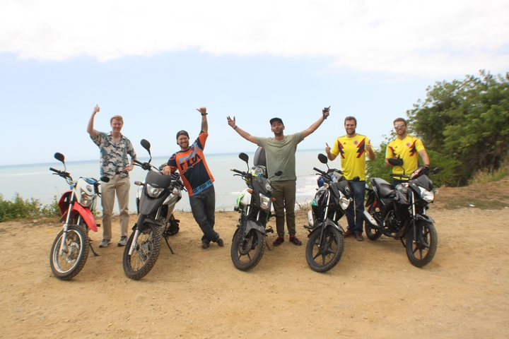       Group of people on motorcycles celebrating with arms raised.
  