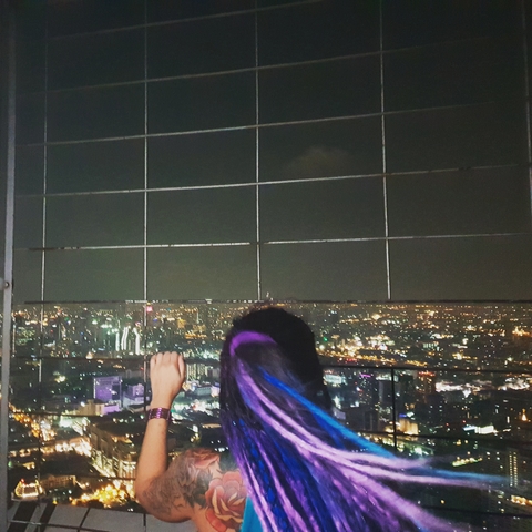 Overhead night view of a city with a person looking out.