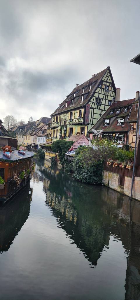      Colorful buildings reflecting in a calm canal.
  