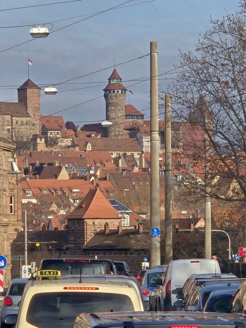 Upside-down street view with cars and a castle in the distance.