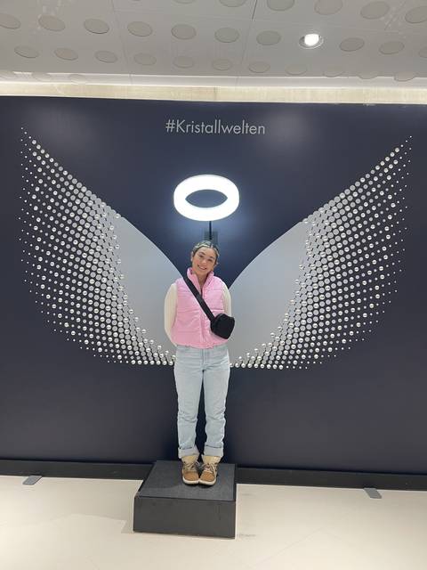 Woman posing in front of a modern art installation indoors.