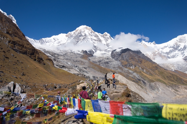 Mountains with snow and prayer flags in the foreground.