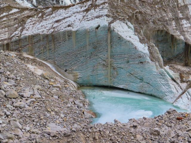 Small, icy blue lake surrounded by rocky terrain.