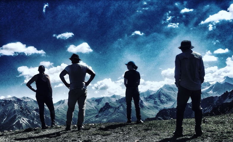 Hikers standing on a ridge with a view of mountains
