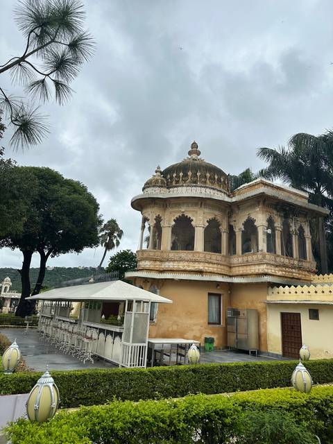 Ornate building with domed rooftops and gardens.