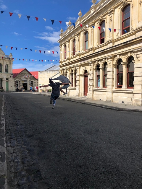 Two people joyfully running down a quaint street.