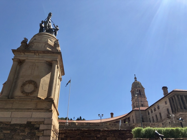       Monument with statues under a clear sky.
  