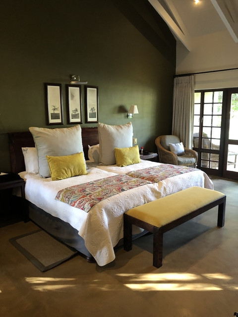       Elegant hotel room with two beds and a window view.
  