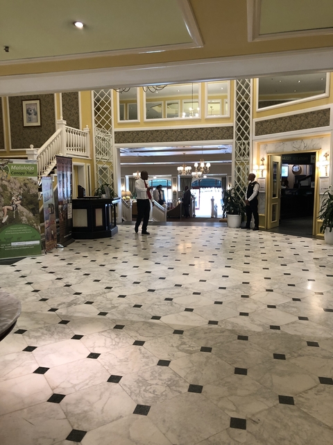       Elegant hotel lobby with marble floors and chandeliers.
  