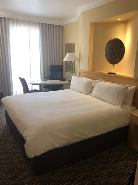       Modern hotel room with a bed and desk.
  