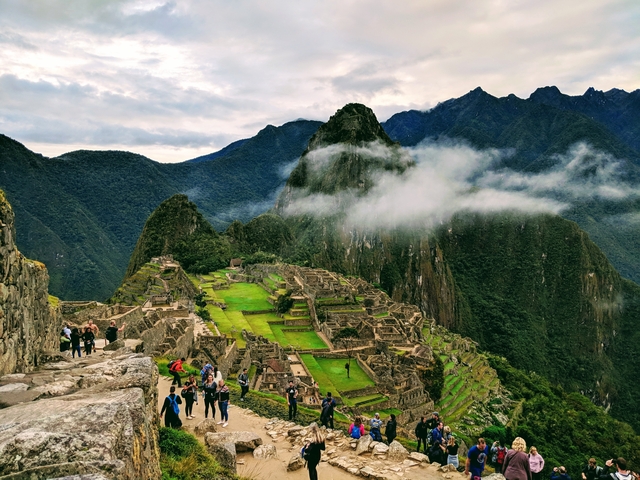 The ancient ruins of Machu Picchu surrounded by lush green mountains and mist.