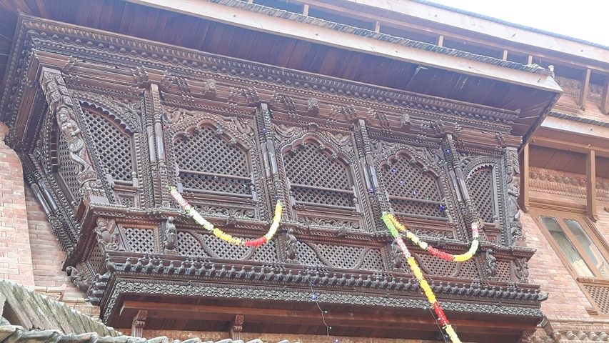       Ornate wooden balcony with traditional carvings.
  