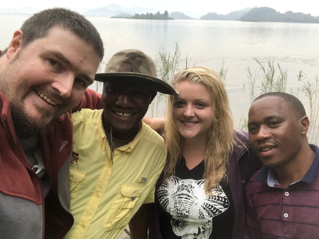 Group of people smiling near a water body.