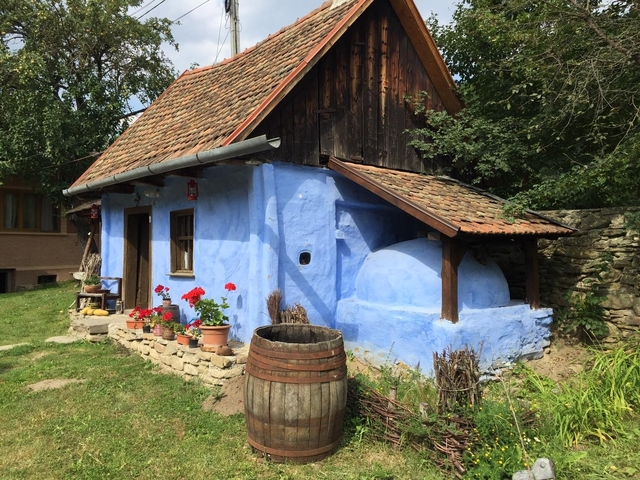 A quaint, traditional blue-painted cottage with flowers.