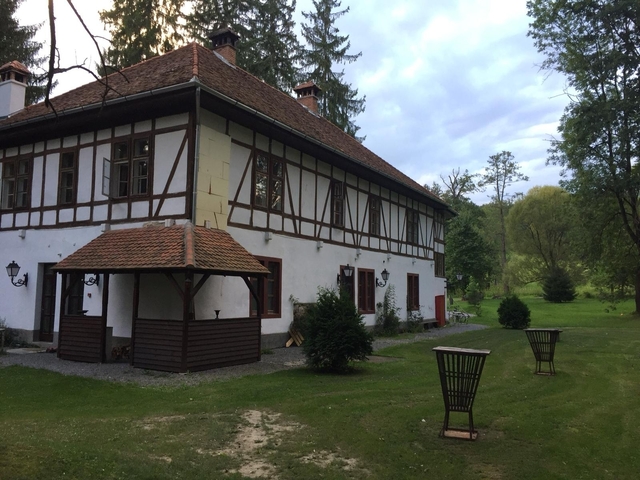 Old European-style house in a grassy landscape.