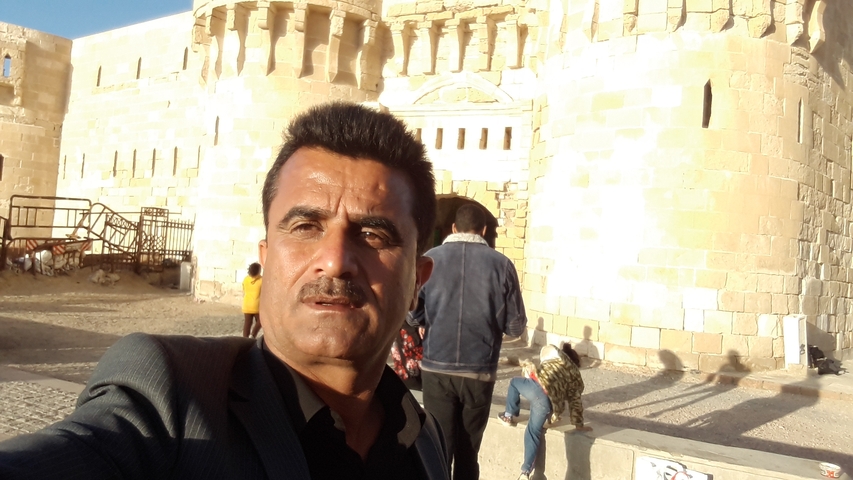 A man taking a selfie in front of ancient ruins.