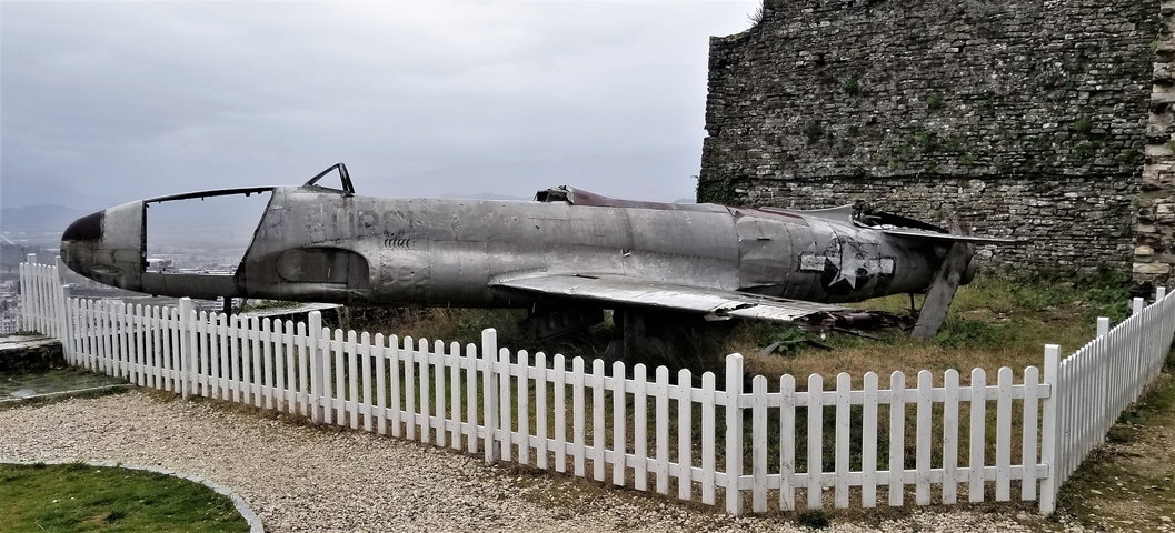       An old military jet displayed in an outdoor area.
  