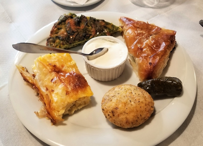       A plate with assorted traditional Albanian pastries and a dip.
  