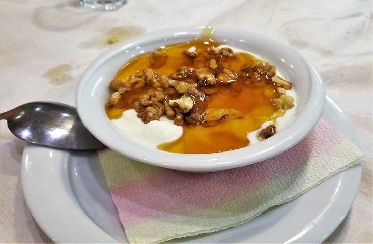       Yogurt with honey and walnuts in a bowl.
  