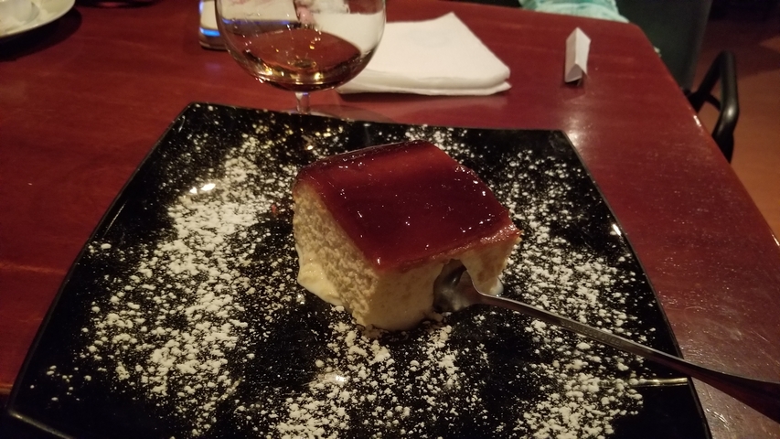       Dessert with a sauce on a black plate.
  