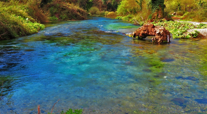       A river with colorful water flowing through a natural landscape.
  