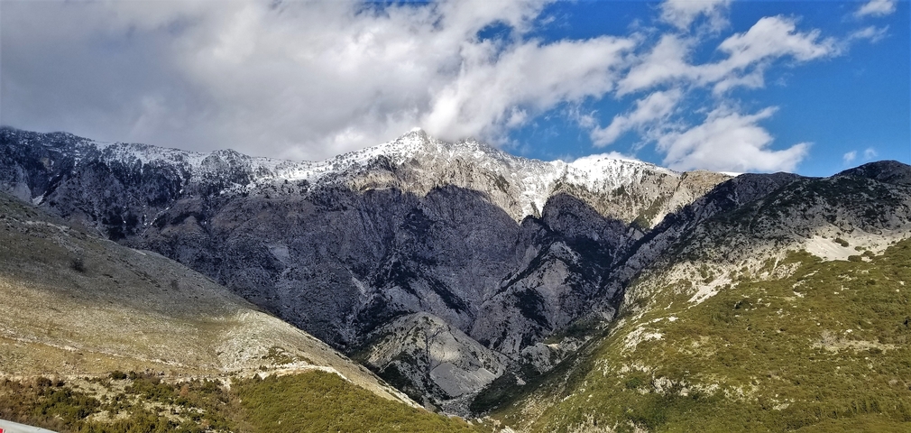       Snow-capped mountains under a blue sky.
  