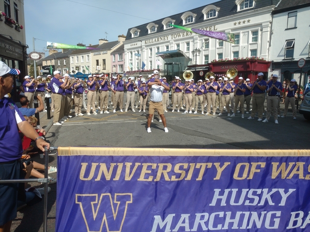 A marching band performing on a street near Killarney Towers Hotel.